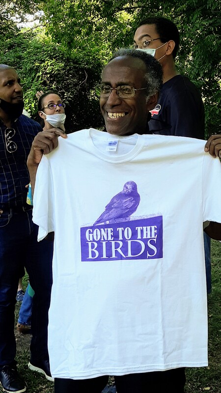 Photo of Adolph White holding a t-shirt that reads 