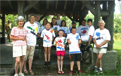 Adult volunteers with youth in group photo at summer camp