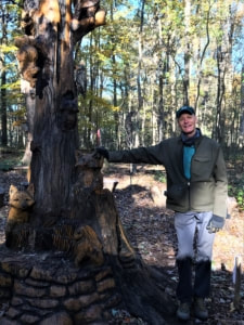 man standing next to a tree