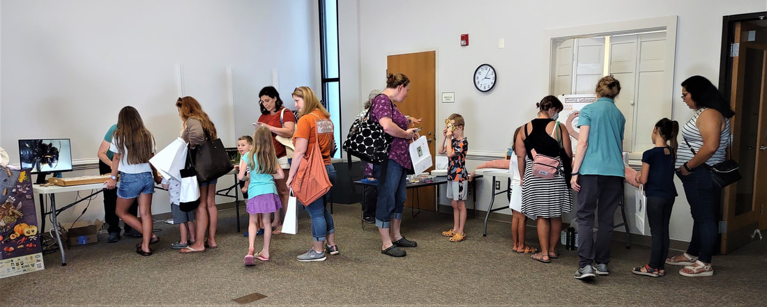 parents and children view displays about nature in a library