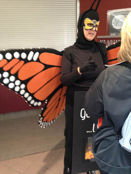 Volunteer teaching in monarch butterfly costume