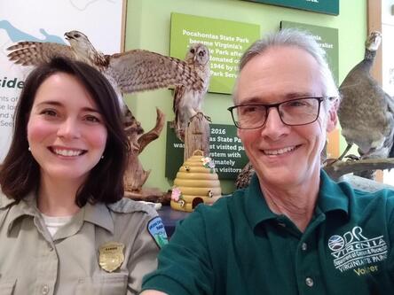 a Virginia State Parks ranger and a volunteer in front of a display about birds