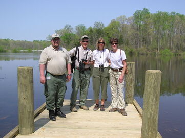 volunteers posed with wildlife agency personnel on lake dock
