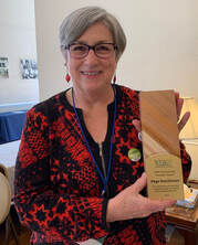 photo of woman holding wooden award plaque