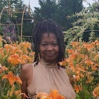 Photo of Bonita Russell standing amongst orange flowers