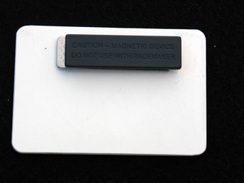 back of nametag with a magnet for attachment. Text reads 