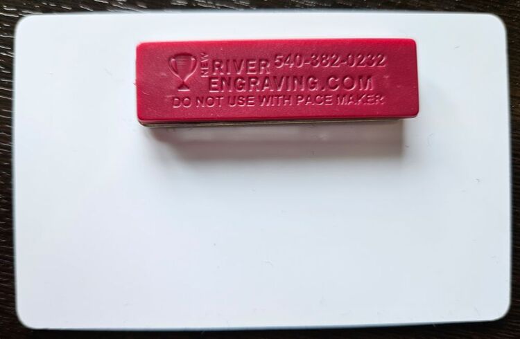 back of nametag with a magnet for attachment. Text reads 