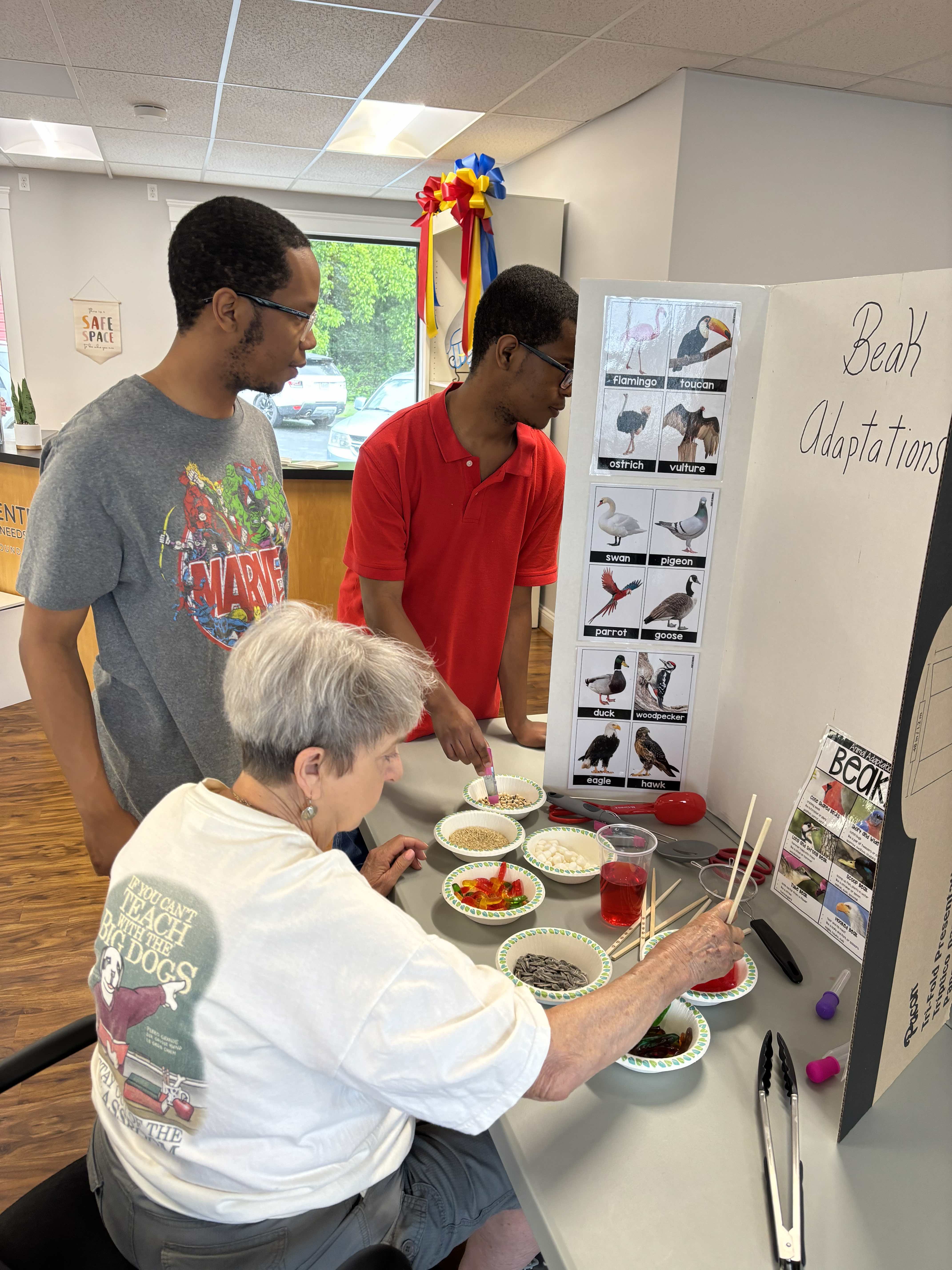 volunteer doing an activity about birds with two teenage youths