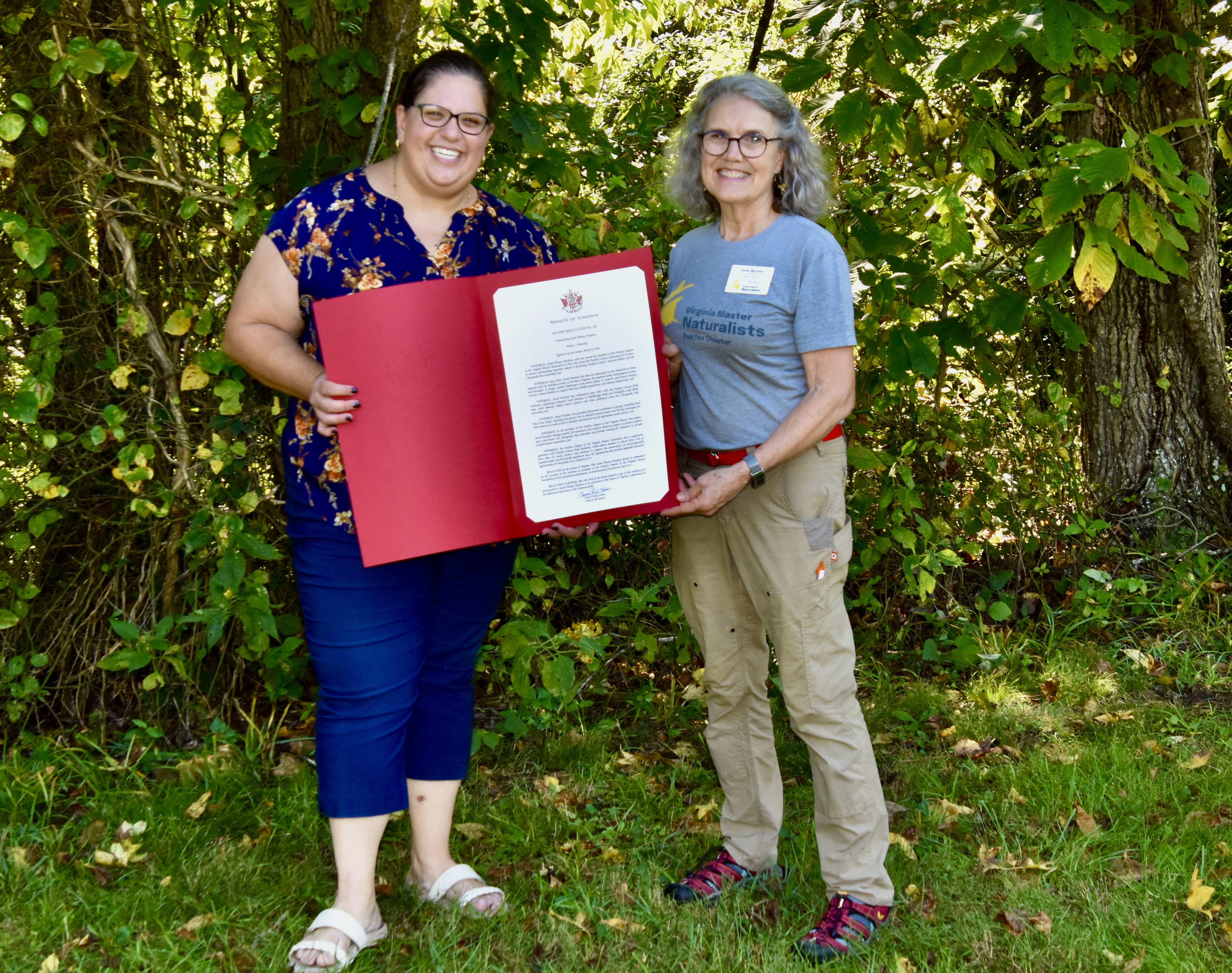 volunteer receiving oversized certificate award from a State Senator