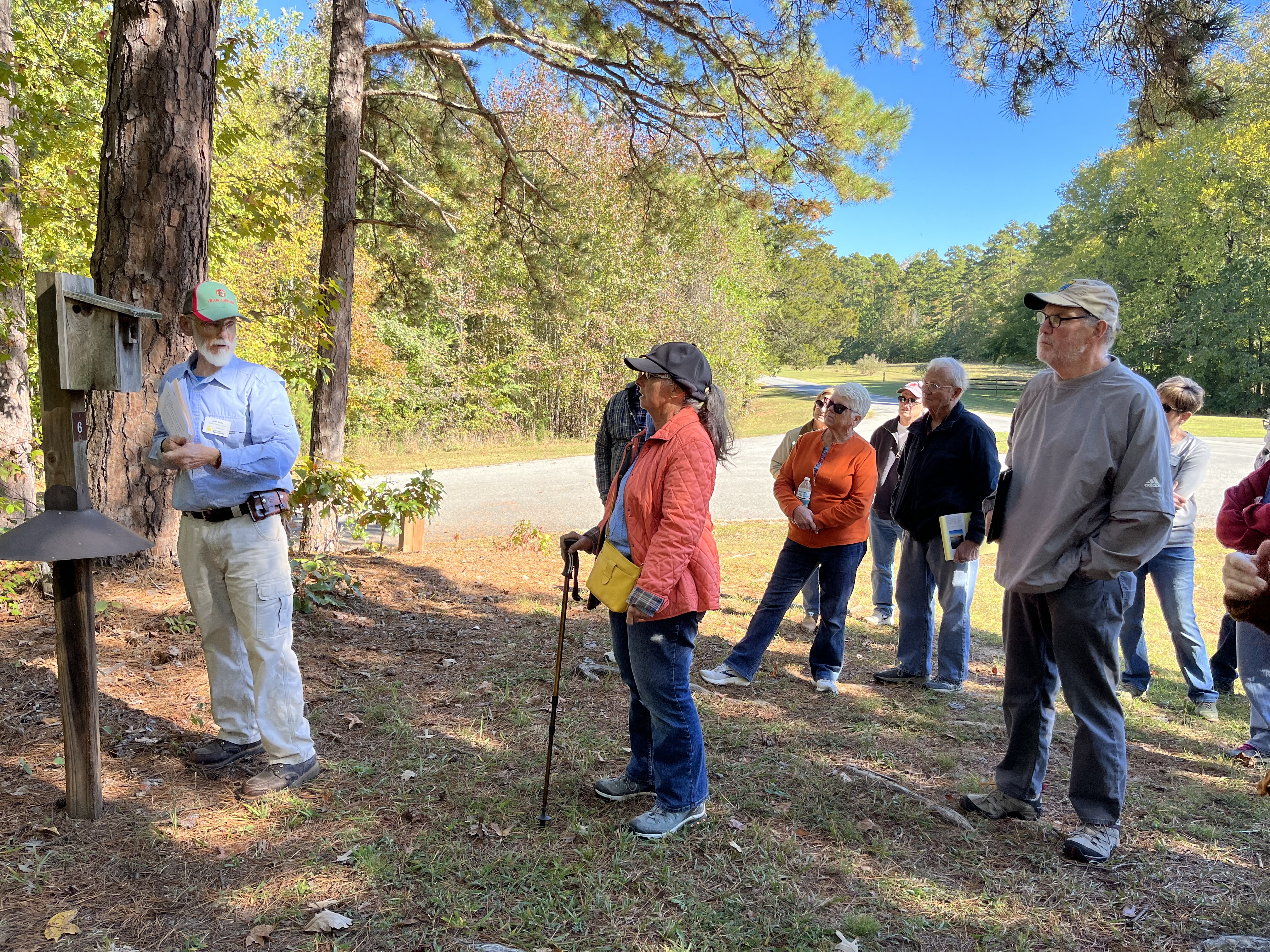 volunteer showing a bluebird box to a group of park visitors