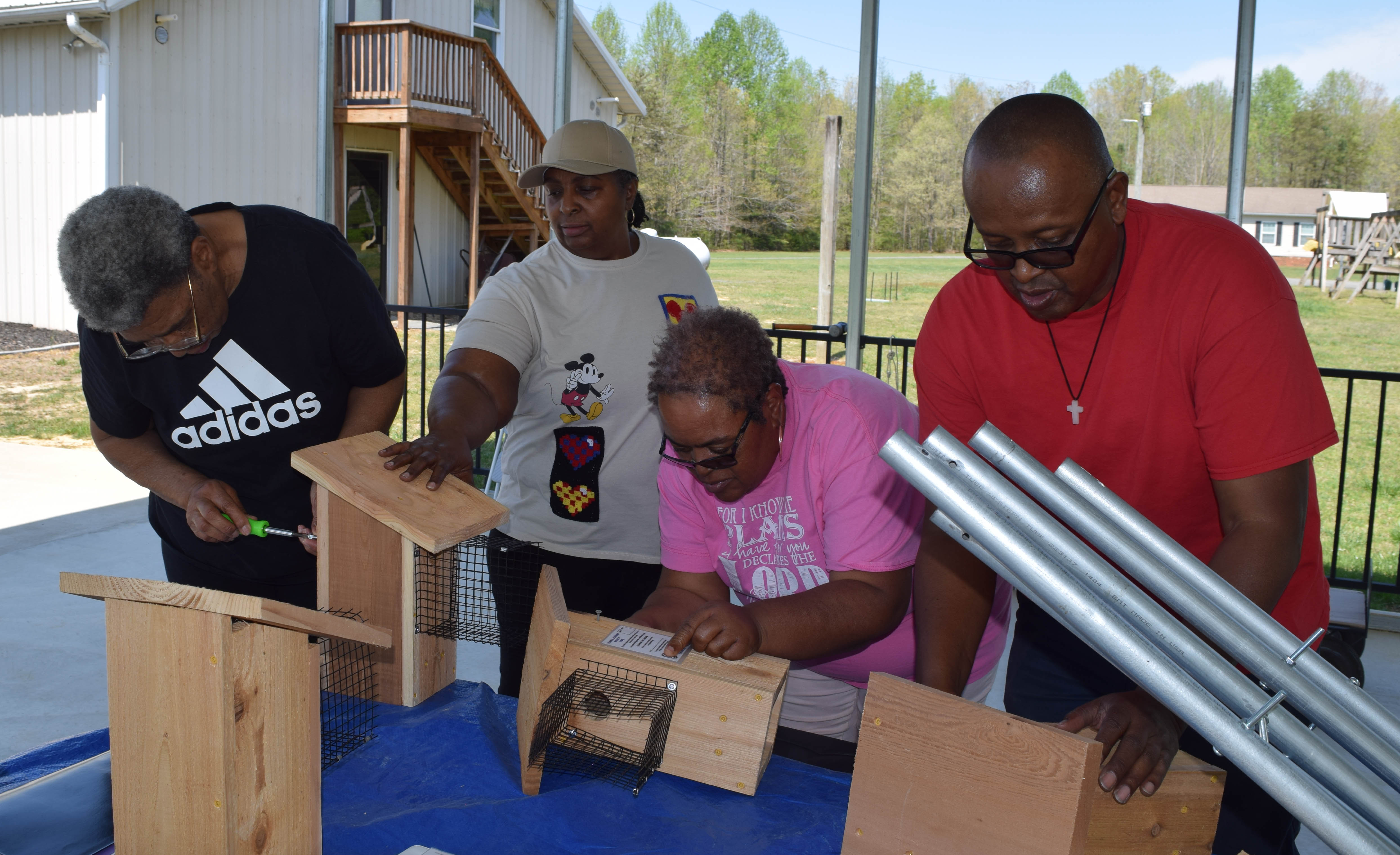 four people building bluebird boxes