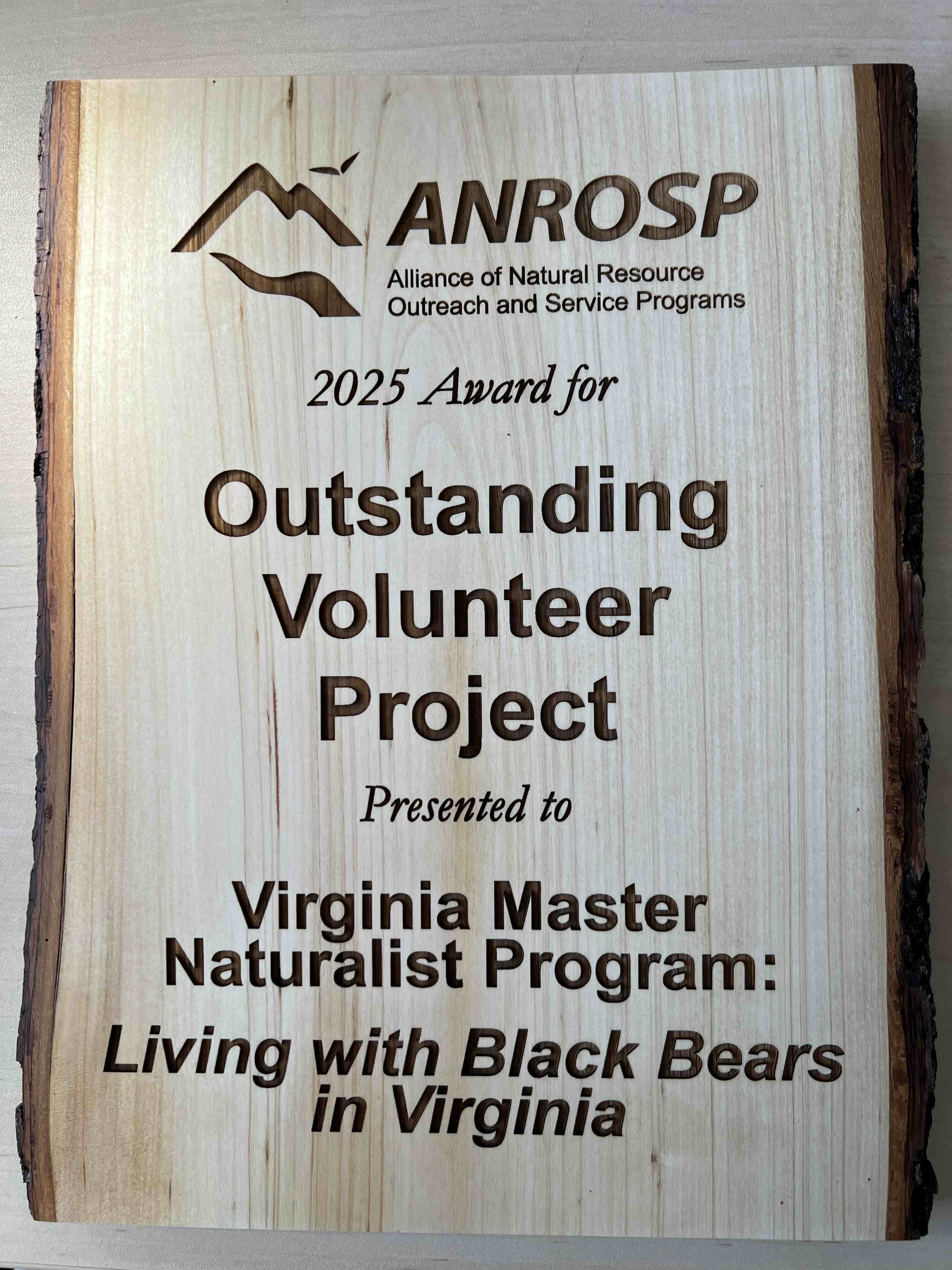 Wooden plaque with text ANROSP Alliance of Natural Resource Outreach and Service Programs, 2025 Award for Outstanding Volunteer Project Presented to Virginia Master Naturalist Program: Living with Black Bears in Virginia