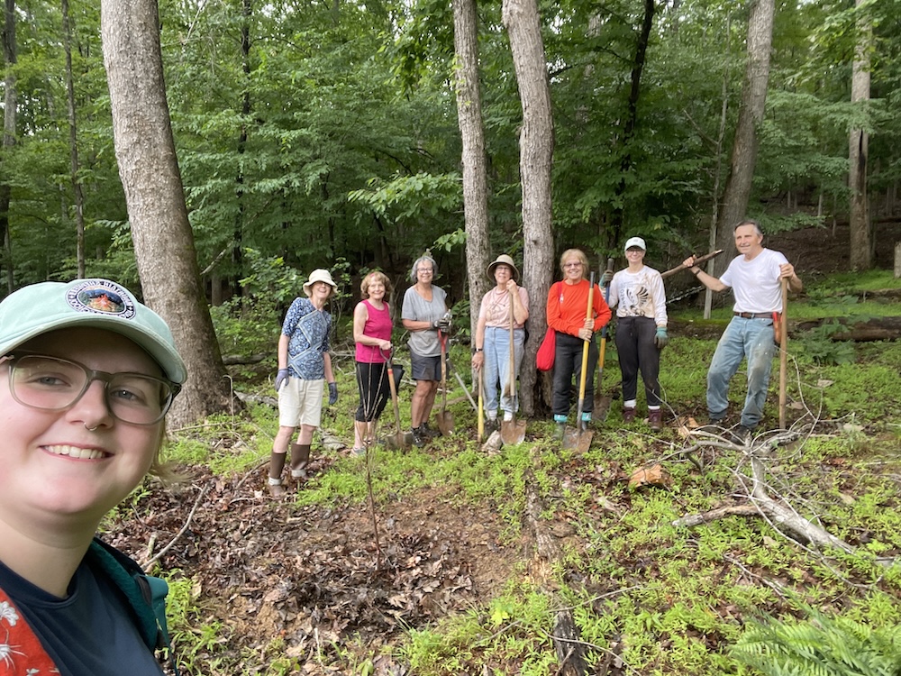 group of volunteers standing in a wooded area