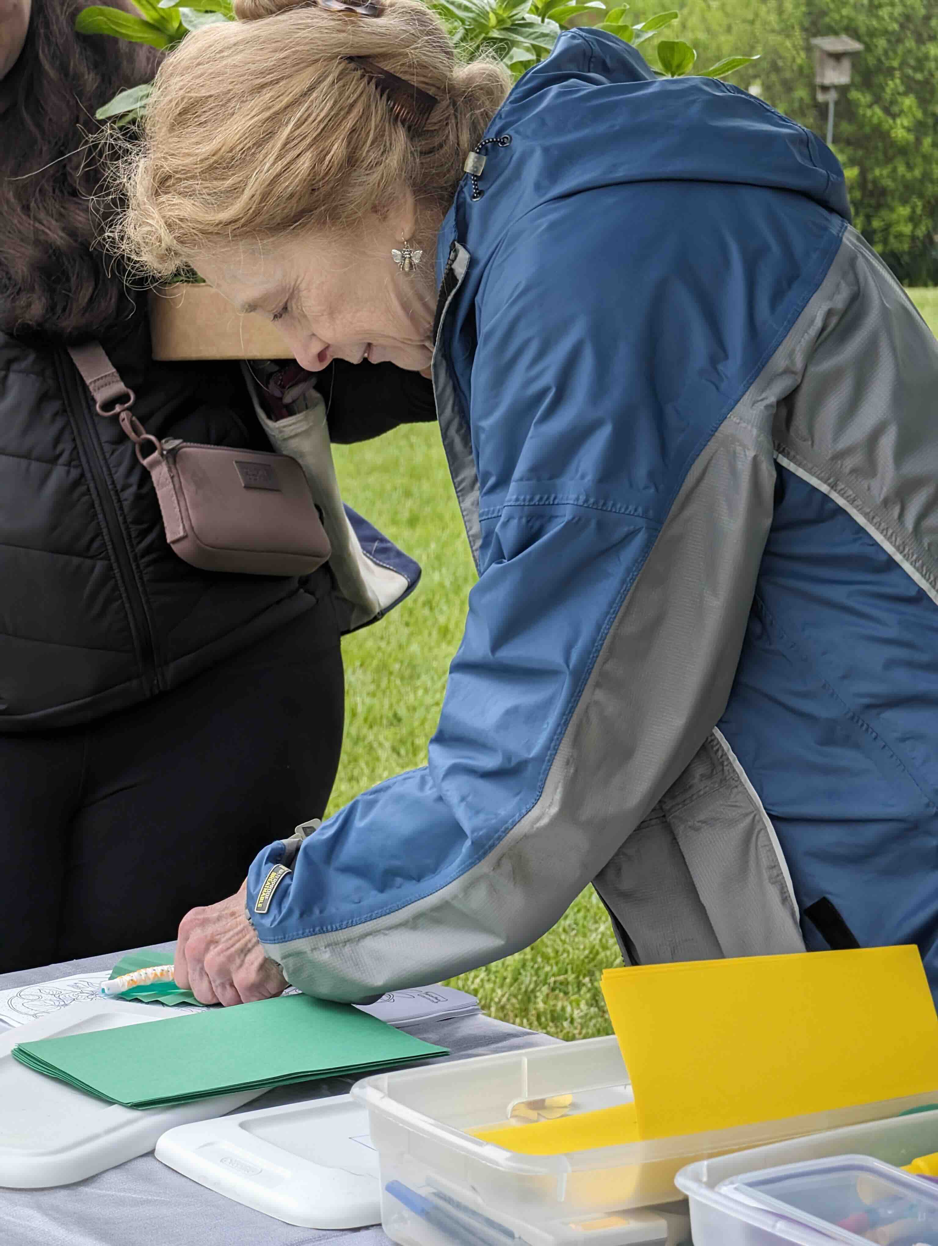 Person bending over a table looking at insects