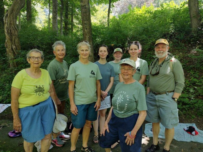 eight volunteers pose near a stream