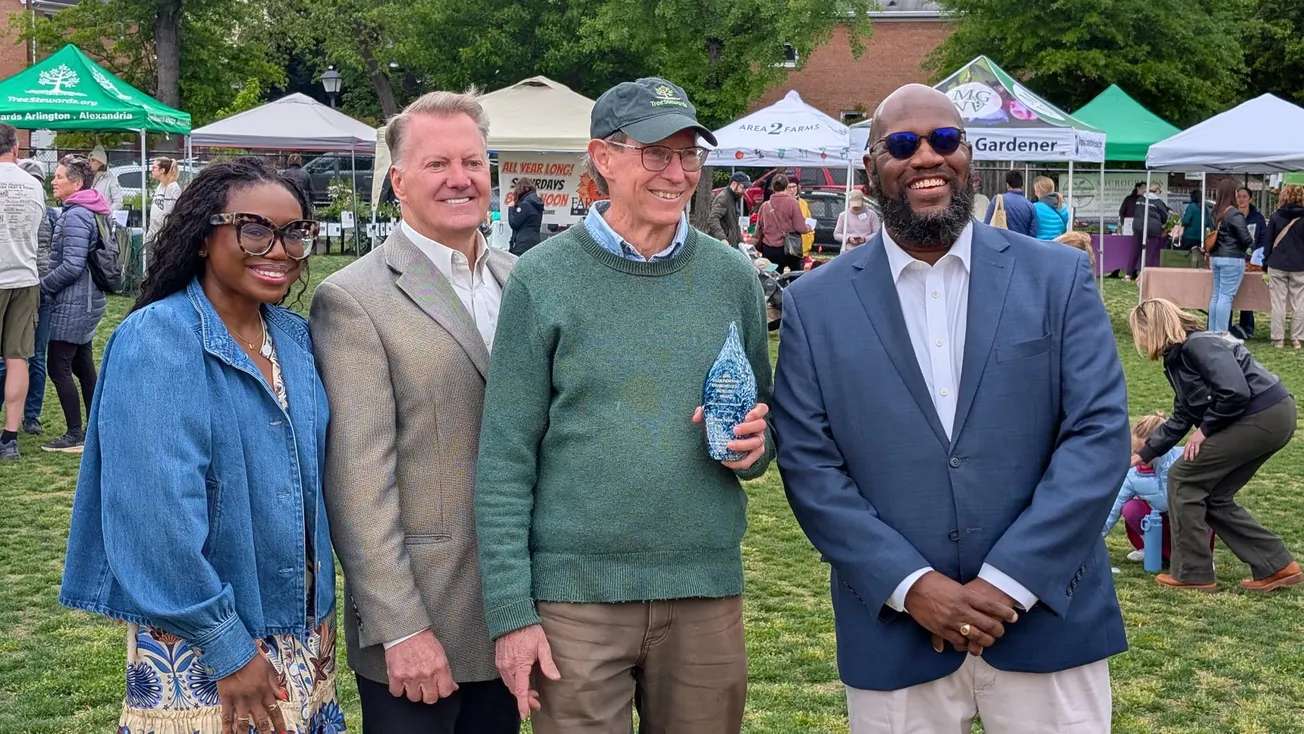 volunteer holds an award trophy, posed with three other adults