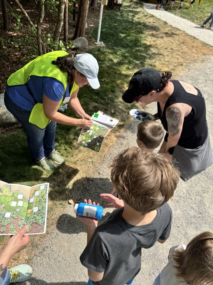 volunteer showing a map to a family with an adult and several children